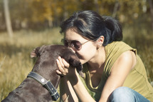 a woman kissing her dog 