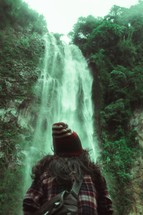 a person standing in front of a waterfall 