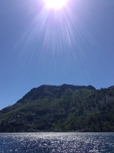 sunburst over a mountain and lake