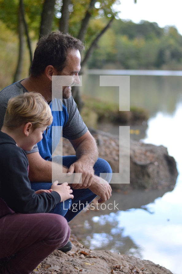father and son together by a lake shore 