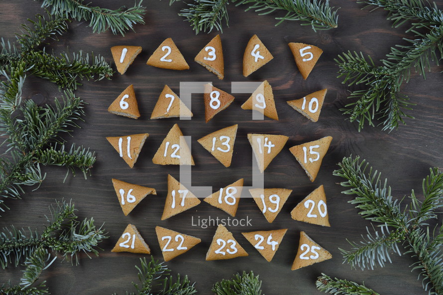 advent cookies on gray wood with pine boughs