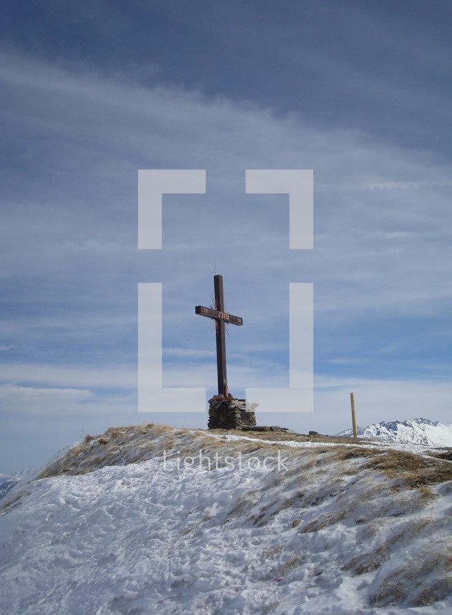 cross on a snow covered mountaintop 