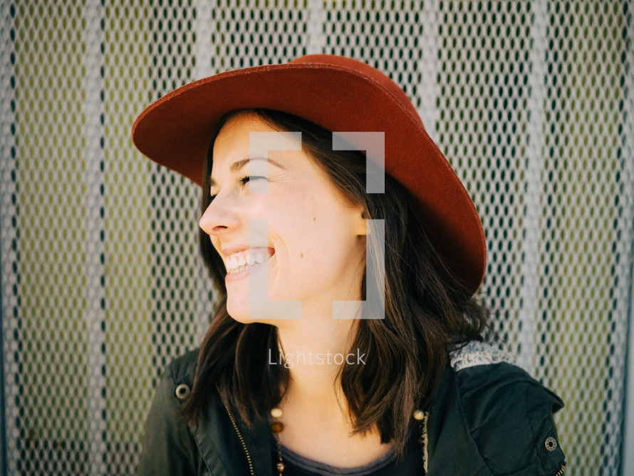 A smiling woman in a hat.