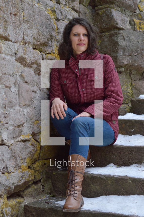 a woman sitting on snowy steps 