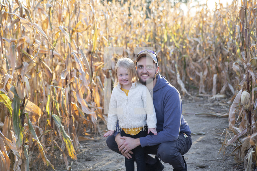 Dad and daughter in corn stalks