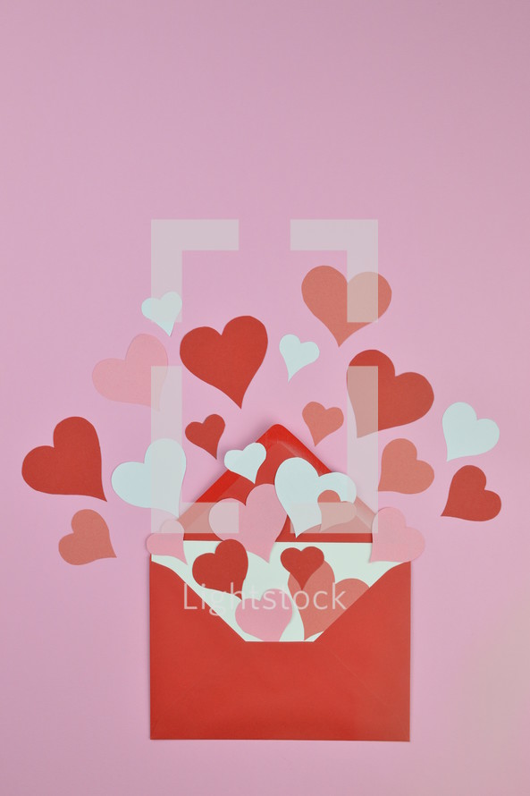 red and pink hearts in a red envelope with copy space above