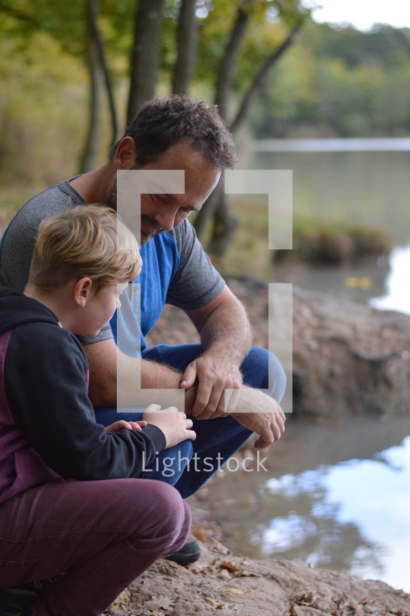 father and son together on a lake shore 