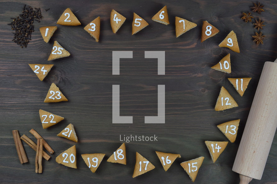 advent cookies on gray wood with rolling pin and spices 