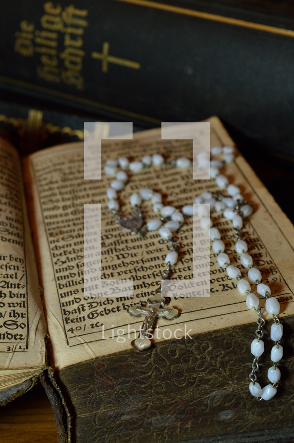 rosary with very old ancient books from Martin Luther and bibles in old German lettering