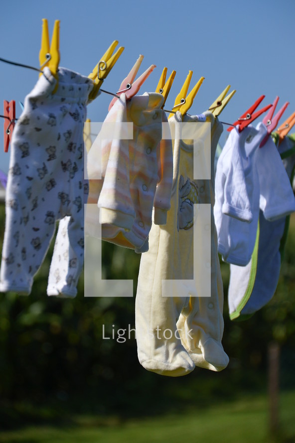 baby clothes drying at a laundry line. birth, birth announcement, 