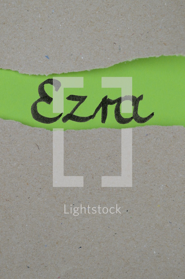 torn open kraft paper over green paper with the name of the book Ezra