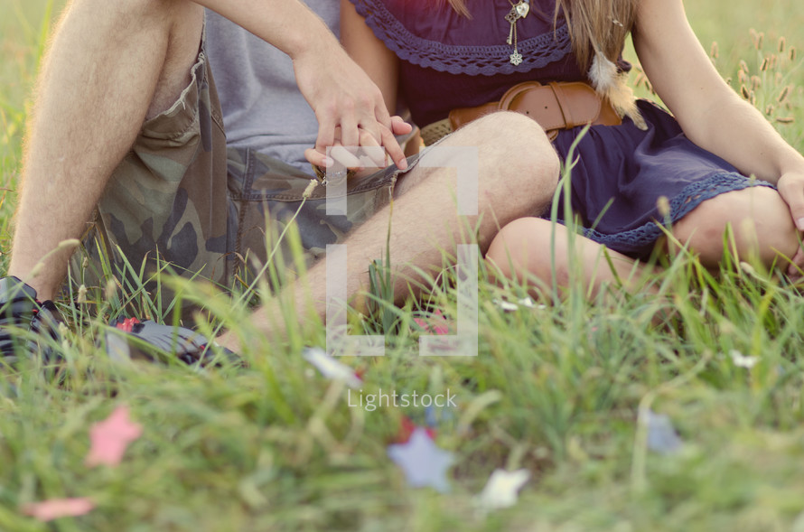 couple holding hands lying in the grass