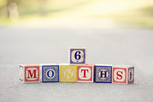 Children's blocks spelling out "6 months."