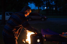 a man tending to flames on a grill 