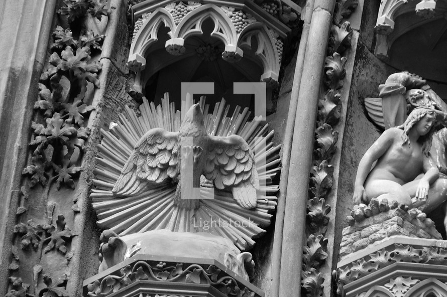 The Holy Spirit in the symbol of a dove at a cathedral entrance portal. 