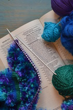 wool and a piece of knitting on a bible open at the page of Proverbs 31: The Wife of Noble Character with the line: She selects wool and flax underlined