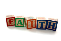 Children's building blocks spelling out Faith on white background. 