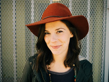 A smiling woman in a red hat.