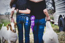 After months of hard work and learning about responsibility, sisters embrace after showing their goats in a county fair.