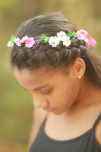 a teen girl with a crown of flowers in a her hair 