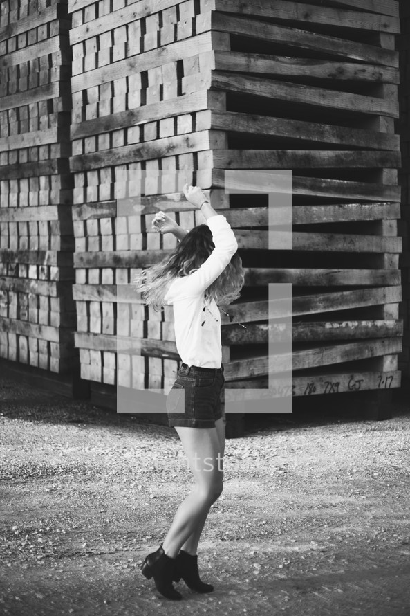 woman posing in front of stacked pallets