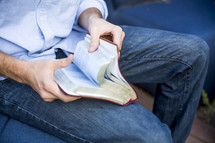 a man reading a Bible in his lap