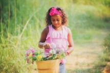 a girl carrying a basket of flowers 