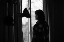 a woman looking out a sliding glass door 