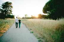 man and woman walking down a gravel road 
