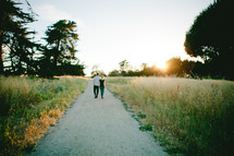 couple walking down a gravel road together 