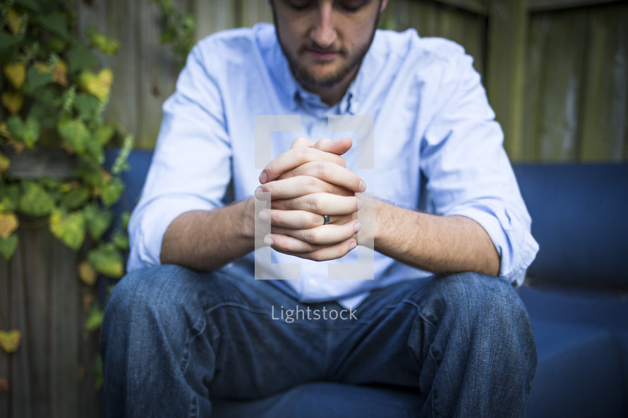 a man in praying in his backyard 