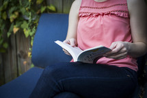a woman reading in her backyard 