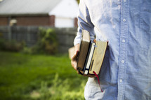 a man carrying journals and Bibles 