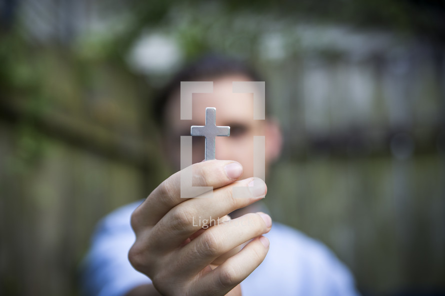 a man holding up a cross