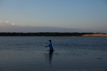fisherman wading in water 