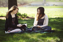 Bible study on a blanket in the grass