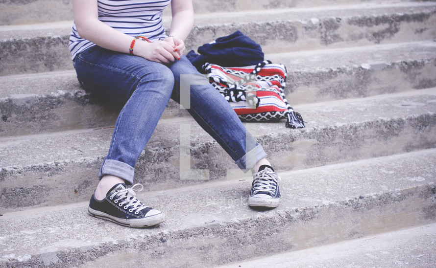 teen sitting on concrete steps 