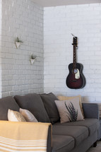 guitar on a wall and couch 