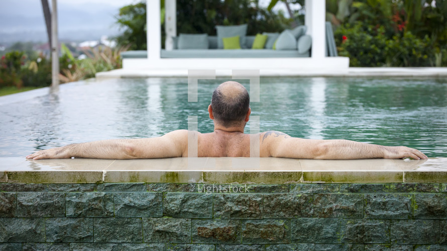 a man relaxing in a swimming pool 