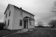 Black and white photo of white farm house