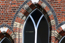 Church windows in red brick wall.