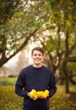 a man holding lemons outdoors 