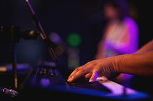 a musician playing a keyboard on stage 