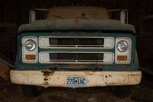 Green, vintage truck in a barn