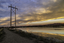 power lines on a shore by a river 