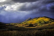 Storm clouds roll in over the colorful fall mountains in Crested Butte Colorado