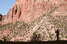 silhouette of a man and red rock cliffs 