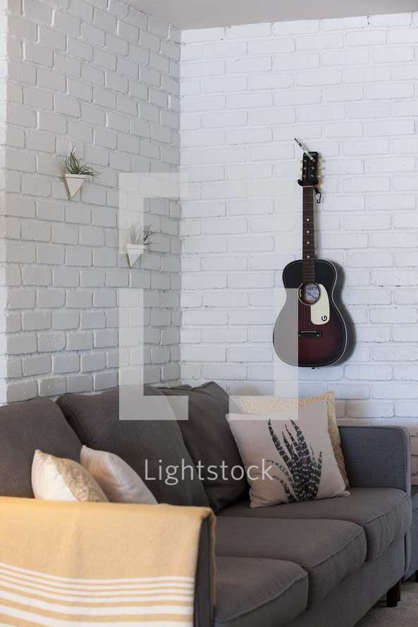 guitar on a wall and couch 