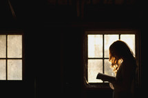 a woman reading by window light 
