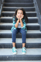 a teen girl sitting on steps 